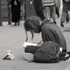 Christoph Radke, New York City, young man squatting on a sidewalk, reading a book, 2016